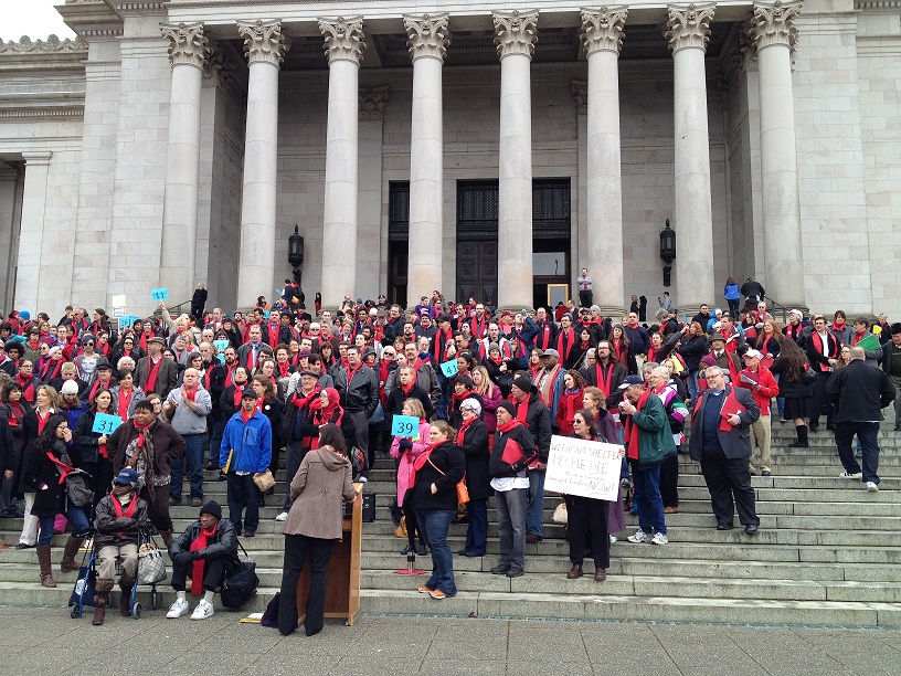 Housing advocates convene on the steps of the state capitol to rally for affordable homes for all.