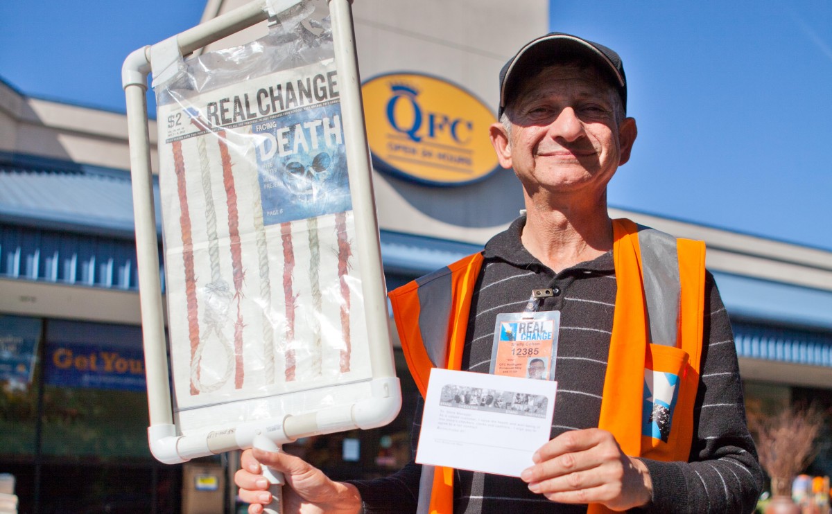 Shelly Cohen has advocated for a number of causes. Here, he holds an advocacy card that customers signed expressing their support for QFC workers during the UFCW 21 Stand With Our Checkers Campaign in  2013. Image credit: Alex Garland.