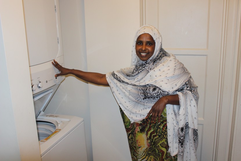 Sahro Farah shows off the washer and dryer at her new affordable apartment. This safe new home is a huge contrast from her previous apartment, where she lived with broken appliances and exposed wires.